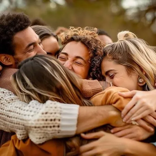 Grupo de personas abrazadas al aire libre